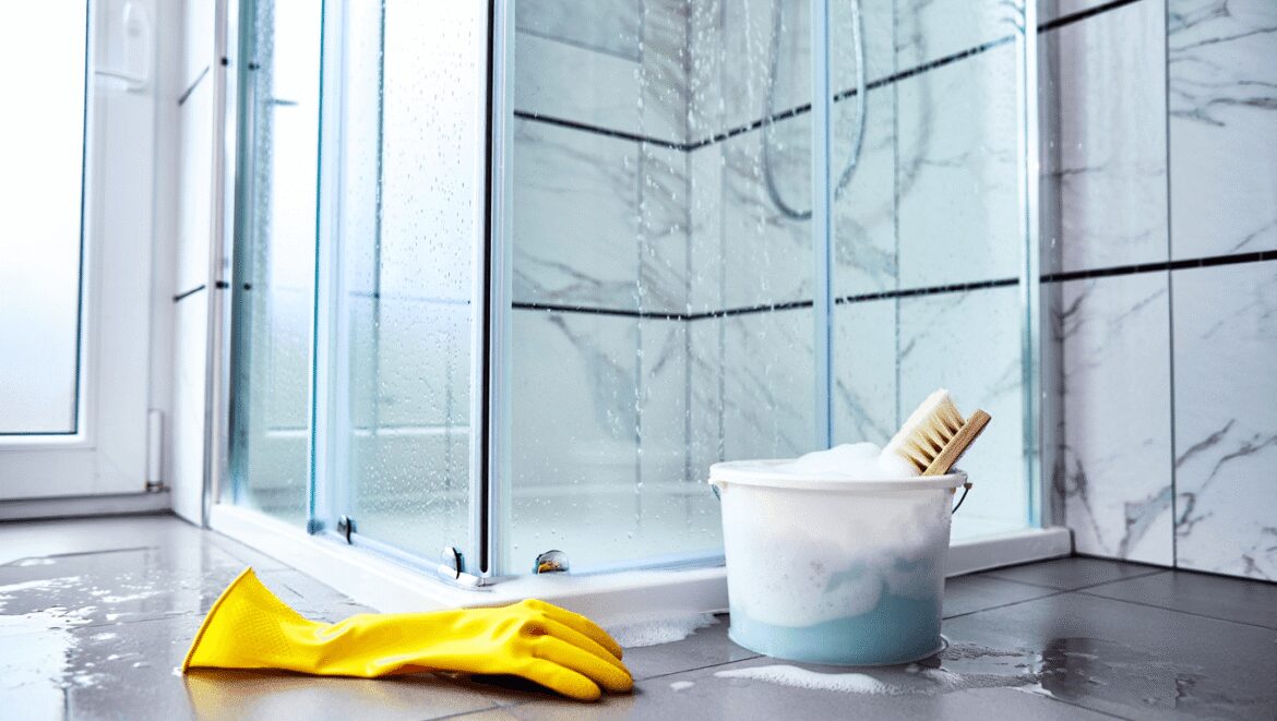 woman smiling and holding a cleaning scrub brush and an electric scrub brush