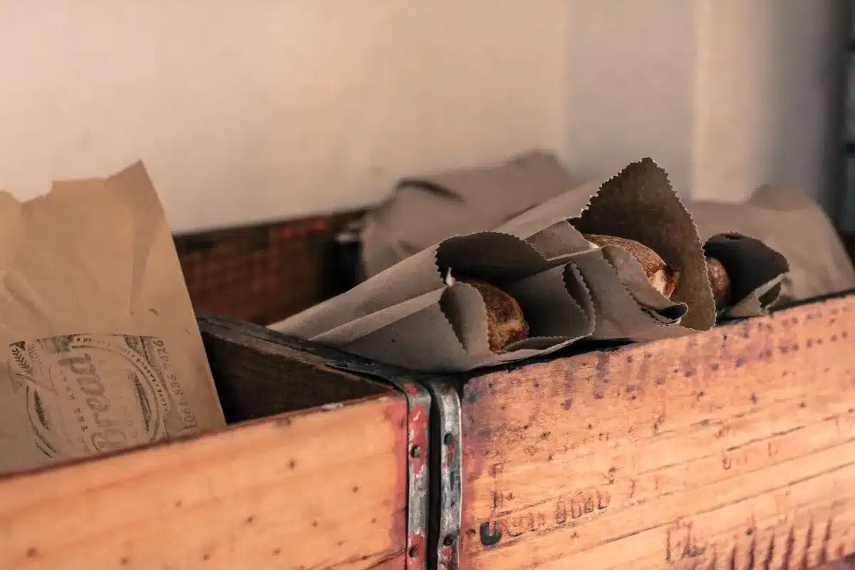 Pain enveloppé dans un sac en toile et rangé dans une boîte à pain en bois