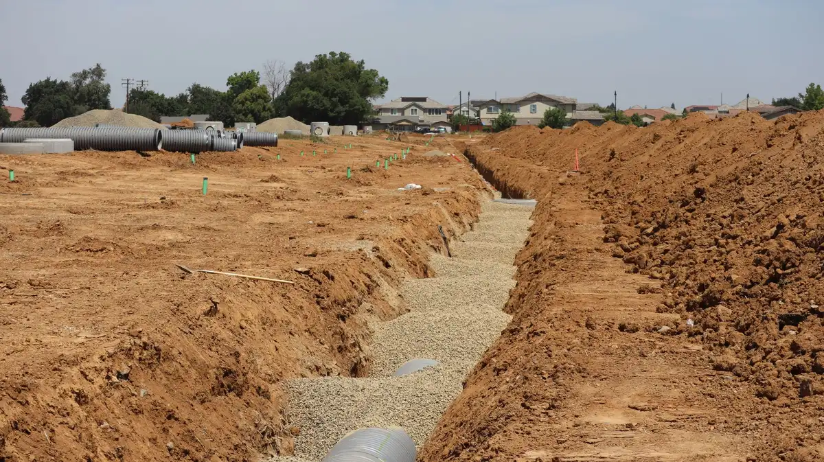 Inspection du sol et du drainage pour évaluer la capacité du terrain à supporter un revêtement en gravier