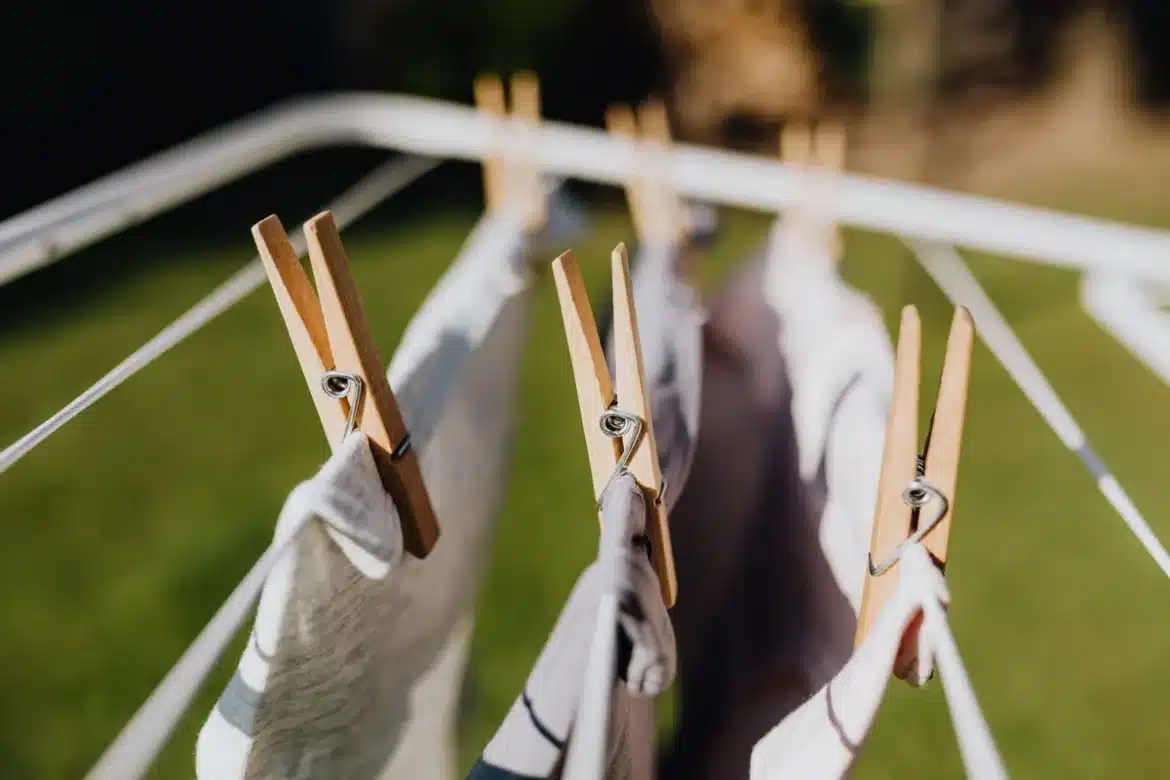 Linge fraîchement lavé étendus sur une corde à linge au soleil avec un panier en rotin et des épingles en bois