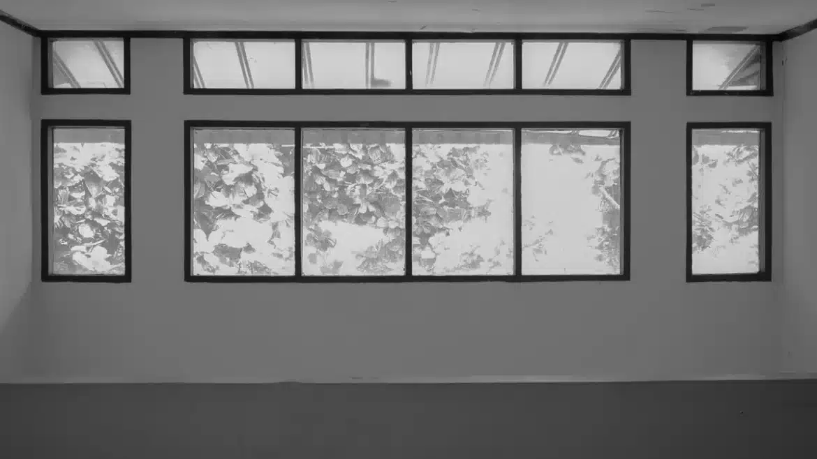 Gros plan sur une main tenant un cadre de fenêtre moderne avec lumière naturelle brillante traversant les vitres