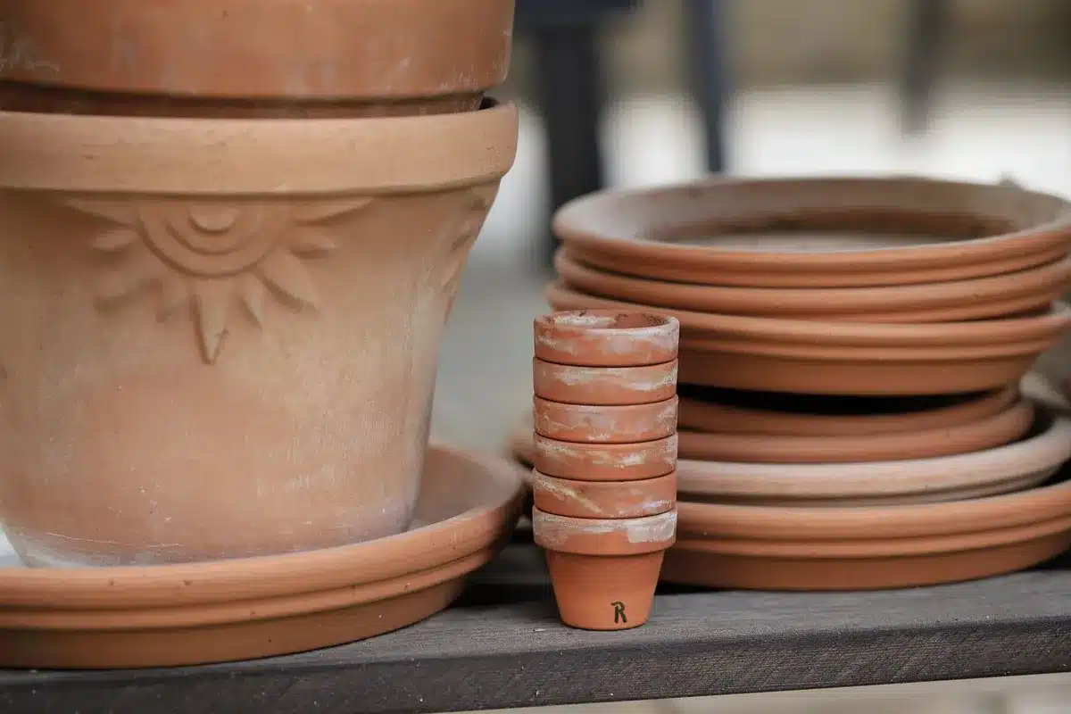 Pot de rangement pour tuyau d'arrosage en style pierre imitation, fermé, posé sur une terrasse