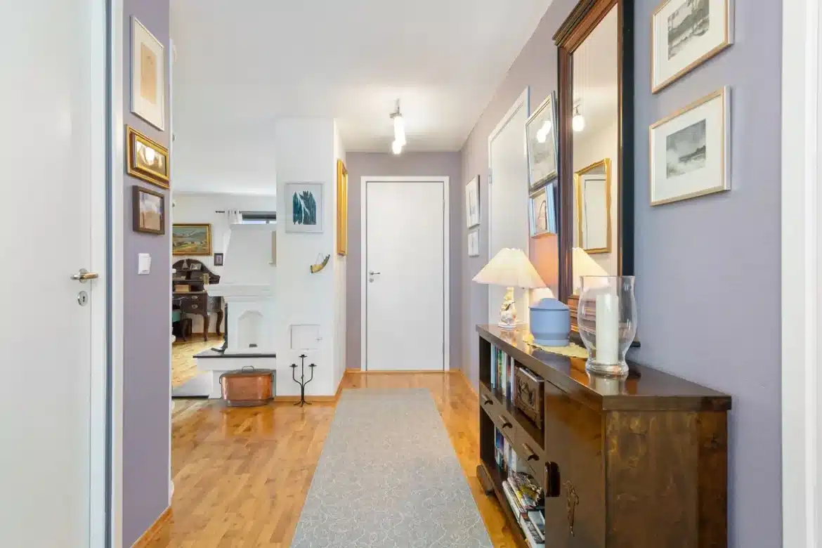 Entrée lumineuse et accueillante avec miroir et console, éclairage superposé créant une ambiance chaleureuse