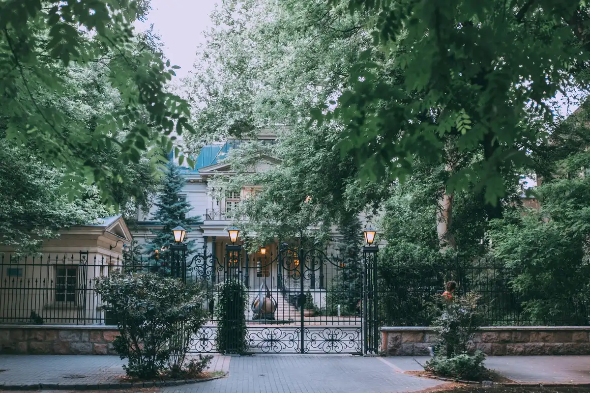 Portail et grille d'entrée d'une maison bourgeoise retirée derrière un mur de clôture