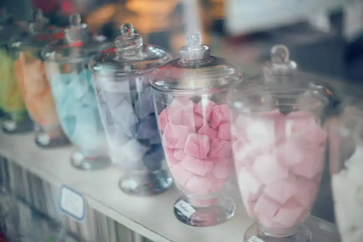 Assortiment de bonbons colorés dans des bocaux en verre sur une étagère