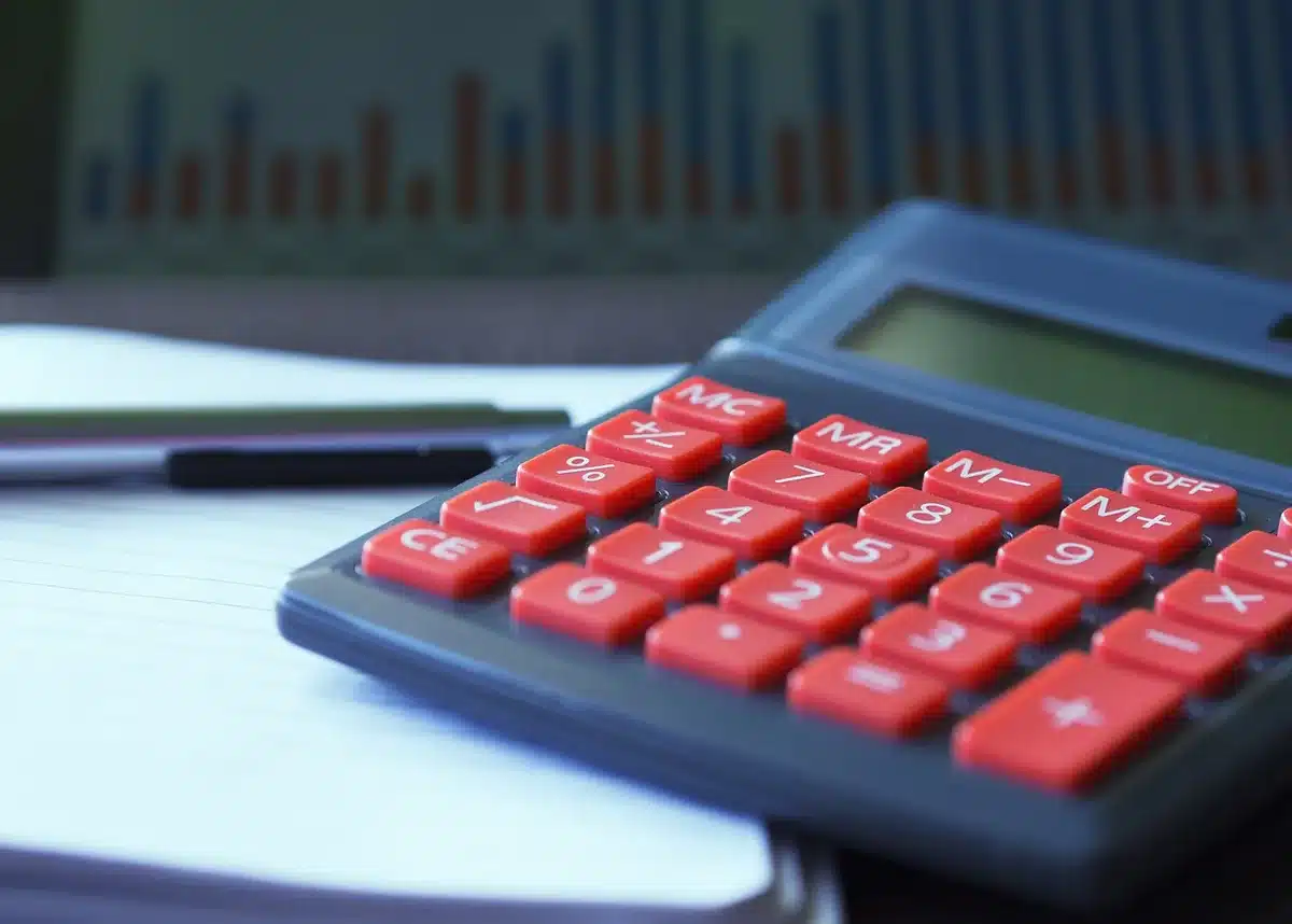 Dossier et calculatrice sur un bureau montrant l'épargne et l'apport personnel
