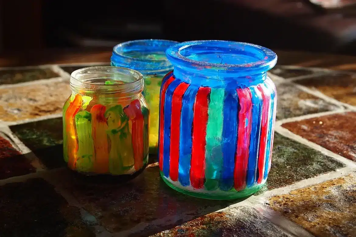 Mains peignant des motifs d'Halloween sur des verres transparents avec des feutres acryliques