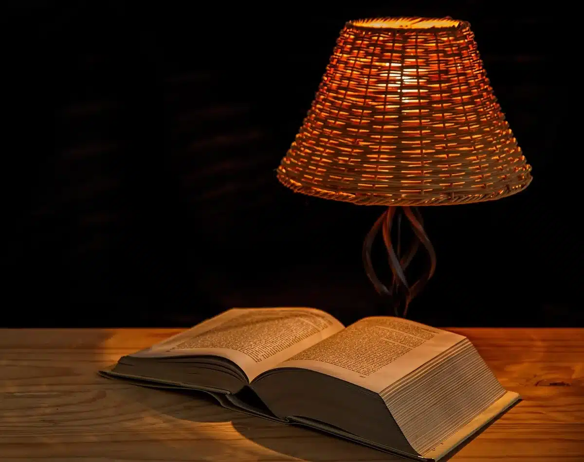 Lampe d'appoint allumée et bougie sur une table, ambiance chaleureuse