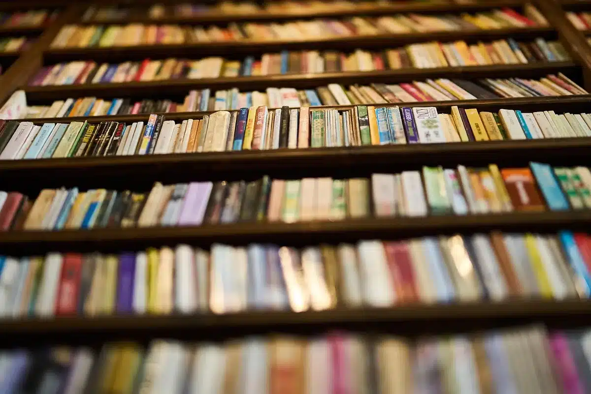 Personne prenant des notes près d'un ordinateur en recherchant des antiquités en ligne